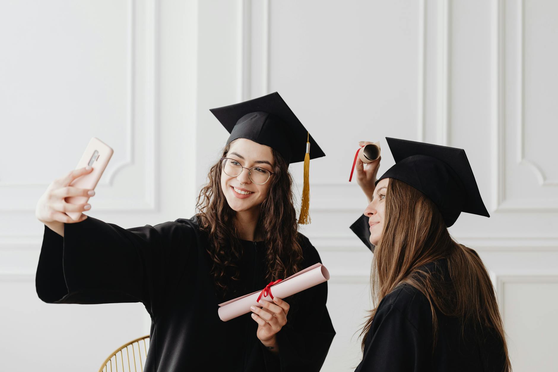 women taking photos wearing their academic dress